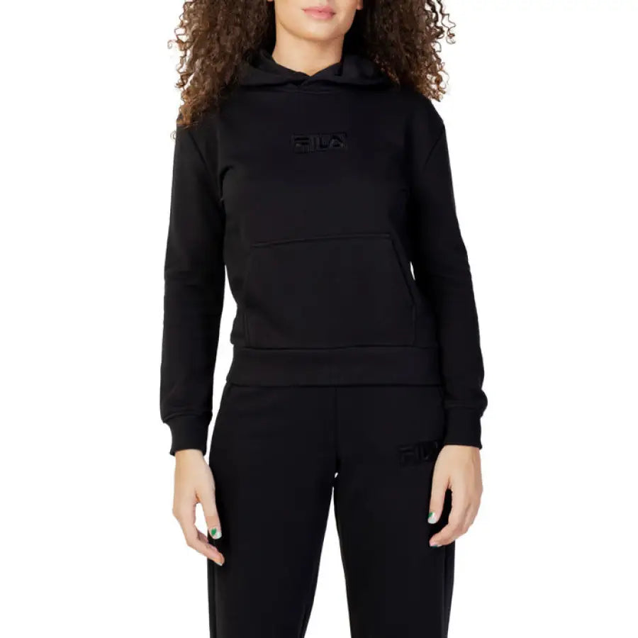 Woman in black Fila hoodie showcasing urban city style fashion