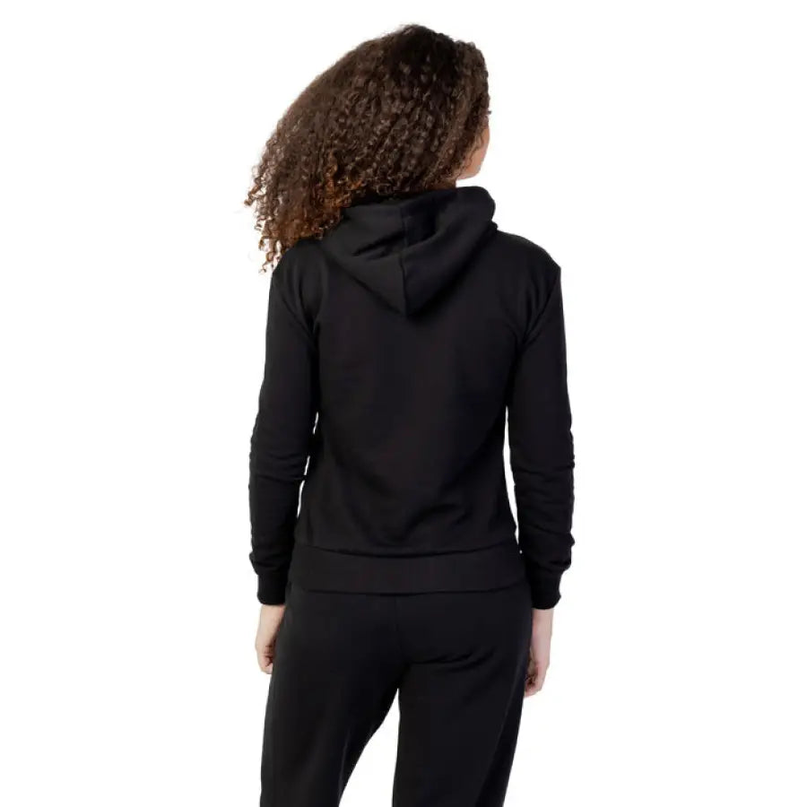 Fila woman in black hoodie and pants showcasing urban city style clothing