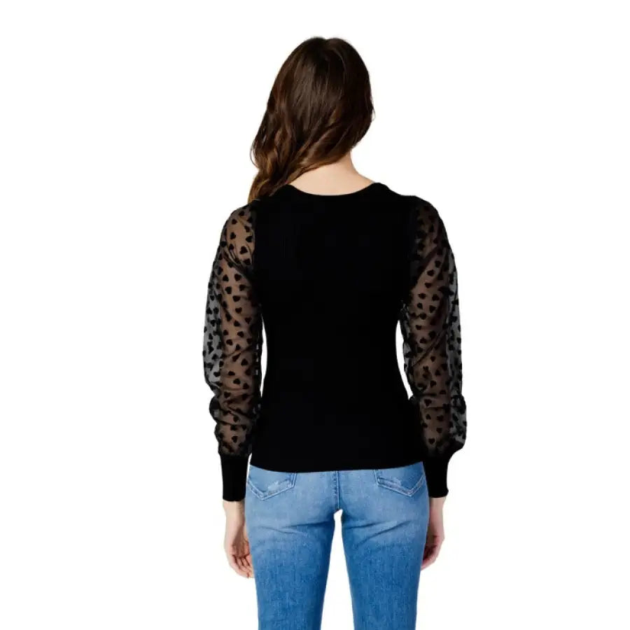 
                      
                        Woman in black polka dot top posing in Only women knitwear for urban city fashion
                      
                    