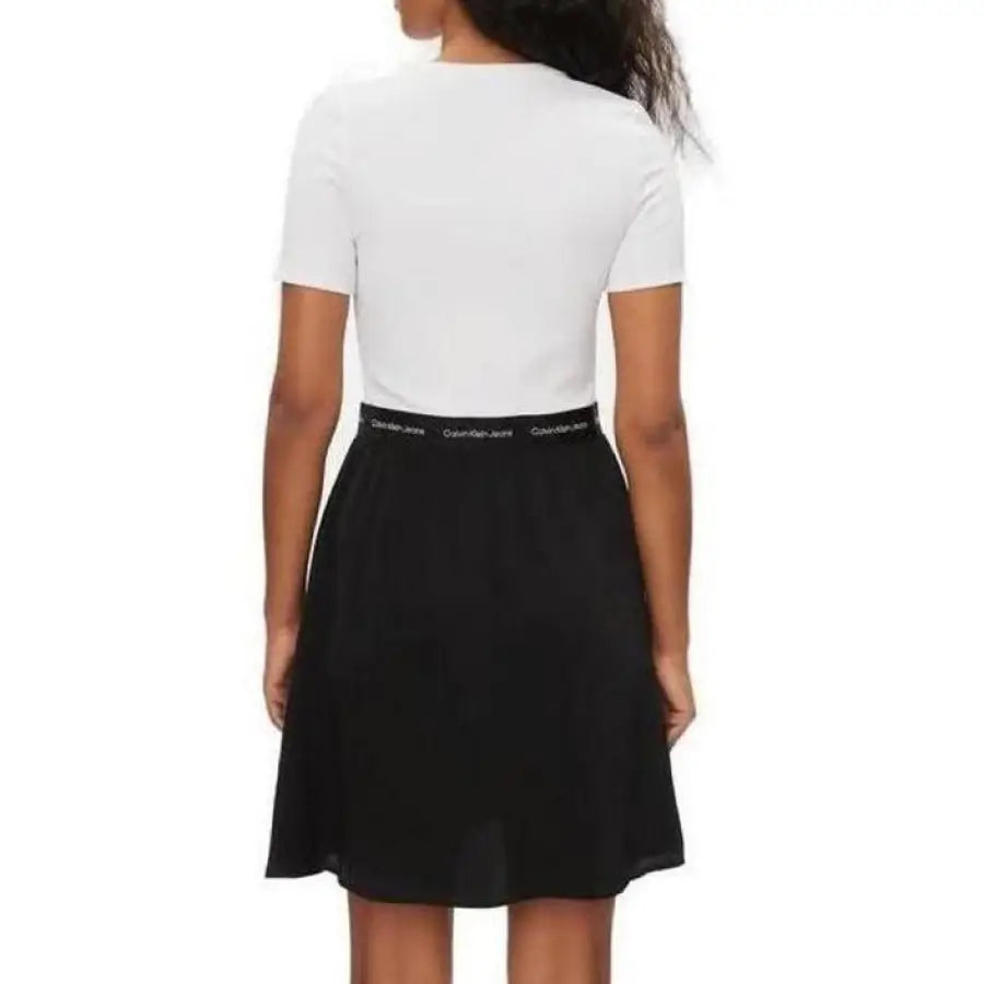 
                      
                        Calvin Klein Jeans women’s dress with model in white shirt and black skirt
                      
                    